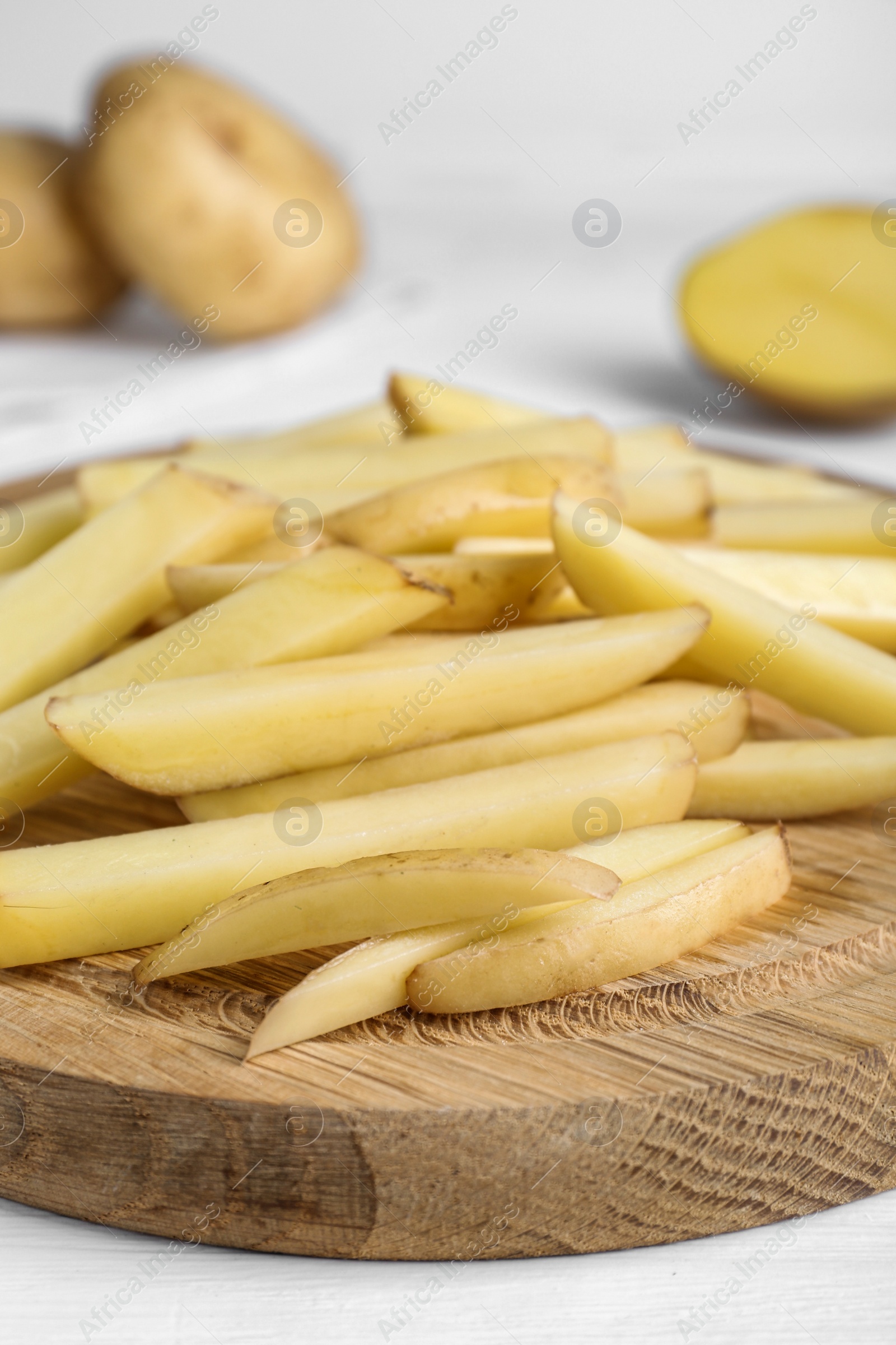 Photo of Cut raw potatoes on white table, closeup