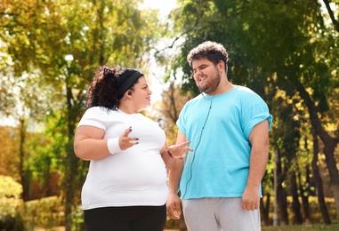 Overweight couple in sportswear together in park