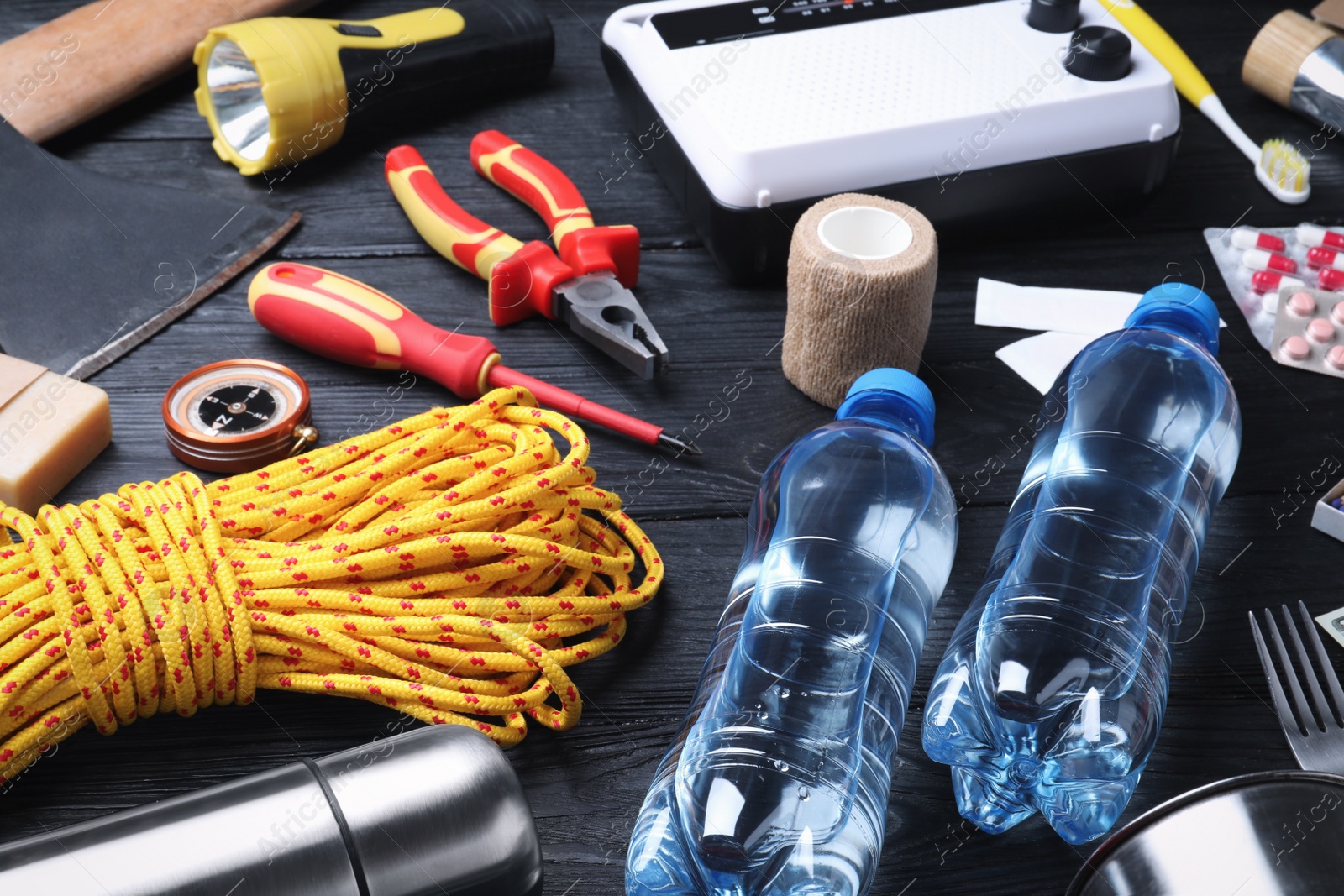 Photo of Disaster supply kit for earthquake on black wooden table