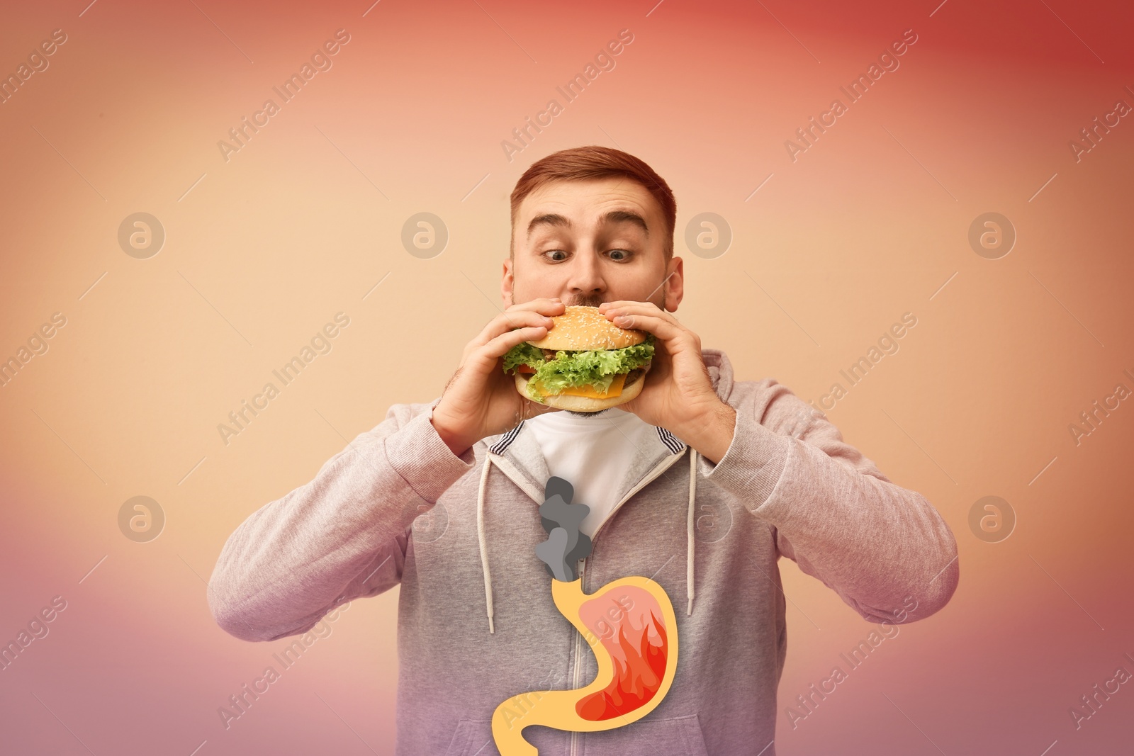 Image of Improper nutrition can lead to heartburn or other gastrointestinal problems. Man eating burger on color background. Illustration of stomach with fire and smoke as acid indigestion