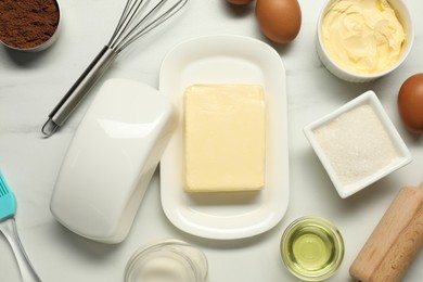 Photo of Flat lay composition with fresh butter among other products on white table