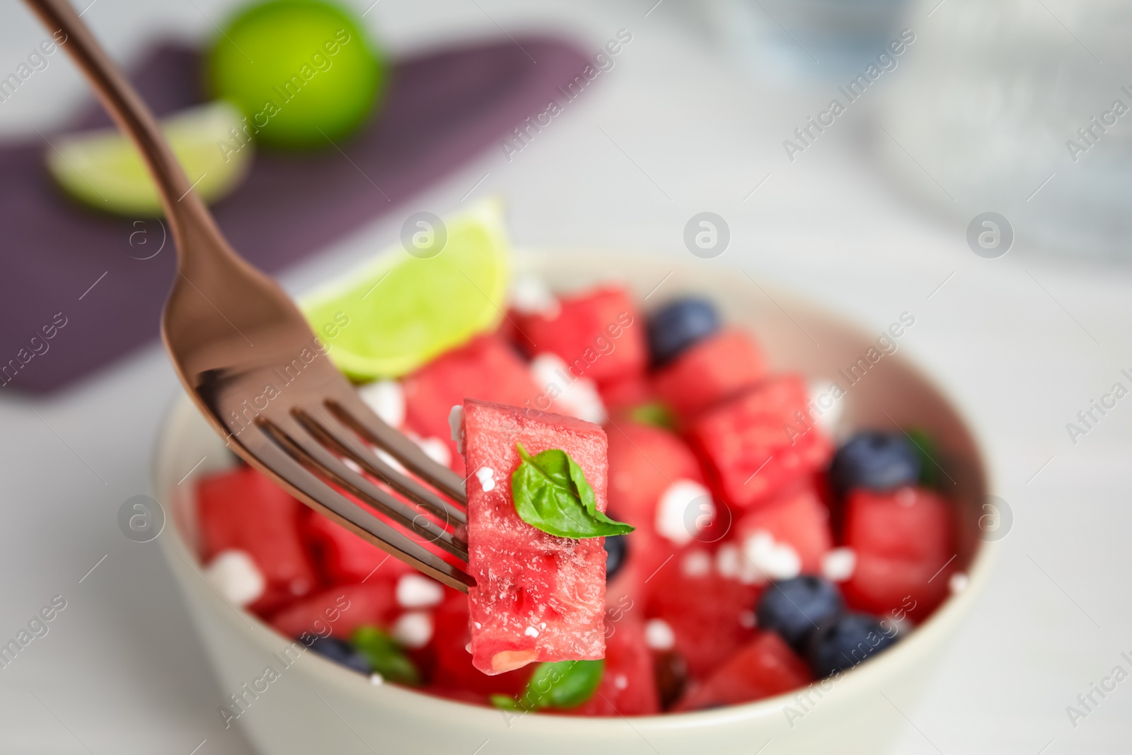 Photo of Delicious salad with watermelon, blueberries and cheese in bowl, closeup