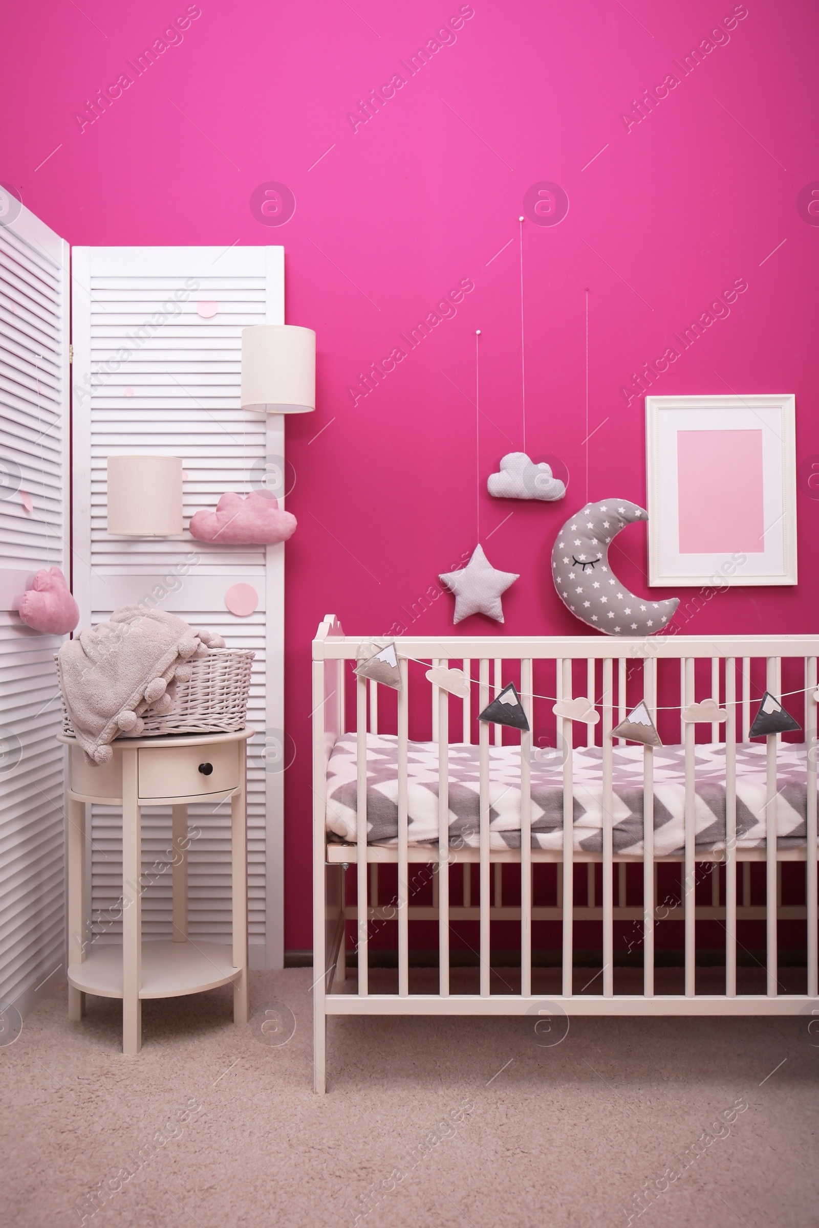 Photo of Baby room interior with crib near color wall