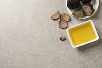 Bowl of truffle oil on light grey table, flat lay. Space for text