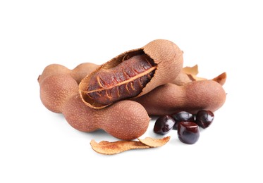 Photo of Delicious ripe tamarinds and seeds on white background. Exotic fruit