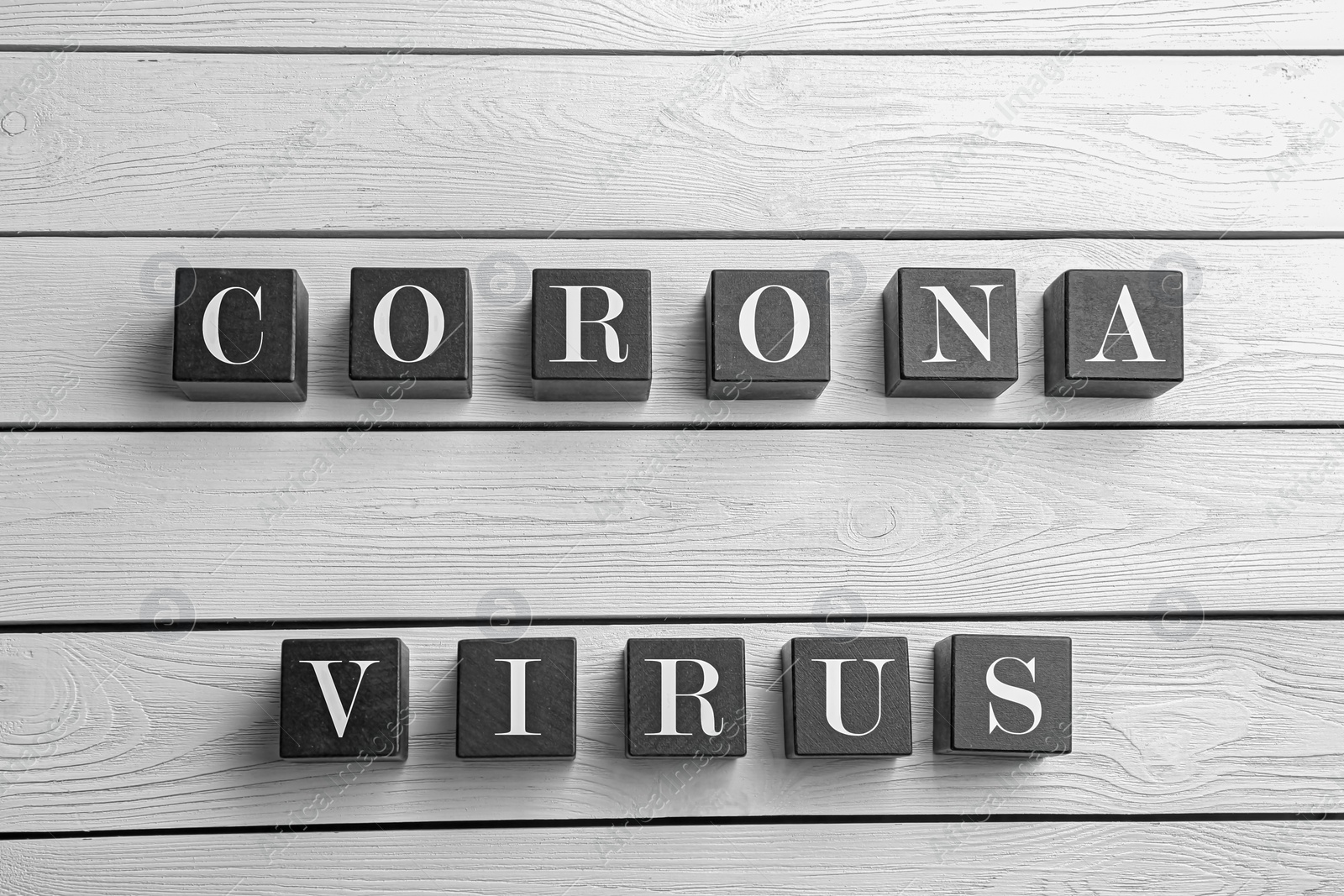 Photo of Words CORONA VIRUS made with black cubes on white wooden background, flat lay