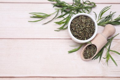 Photo of Dry and fresh tarragon on wooden table, flat lay. Space for text