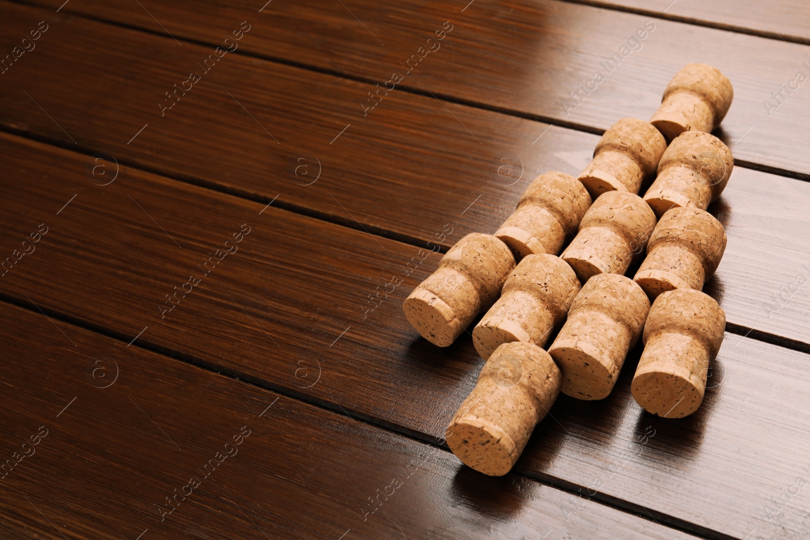 Photo of Christmas tree made of wine corks on wooden table. Space for text