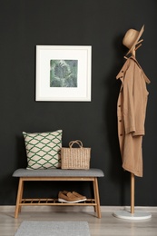 Bench with pillow and bag at black wall. Interior design