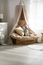 Photo of Comfortable armchair in modern baby room interior