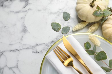 Festive table setting with autumn decor on white marble background, flat lay. Space for text