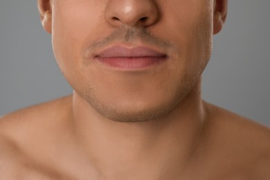 Man after shaving on grey background, closeup