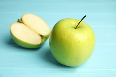 Photo of Fresh ripe green apples on blue wooden table, closeup view. Space for text