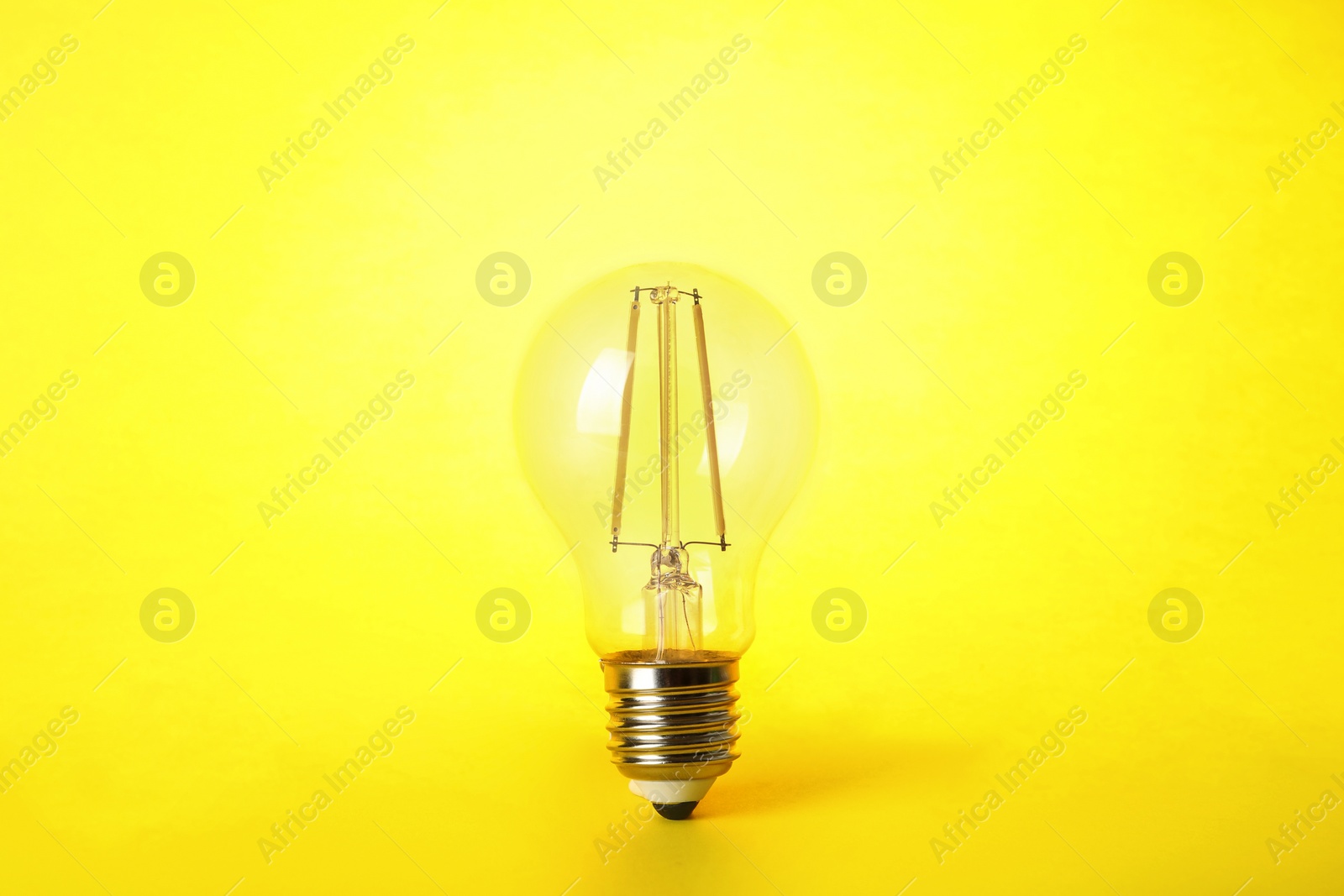 Photo of Vintage filament lamp bulb on yellow background