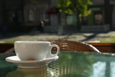 Cup of fresh aromatic coffee at table in cafe