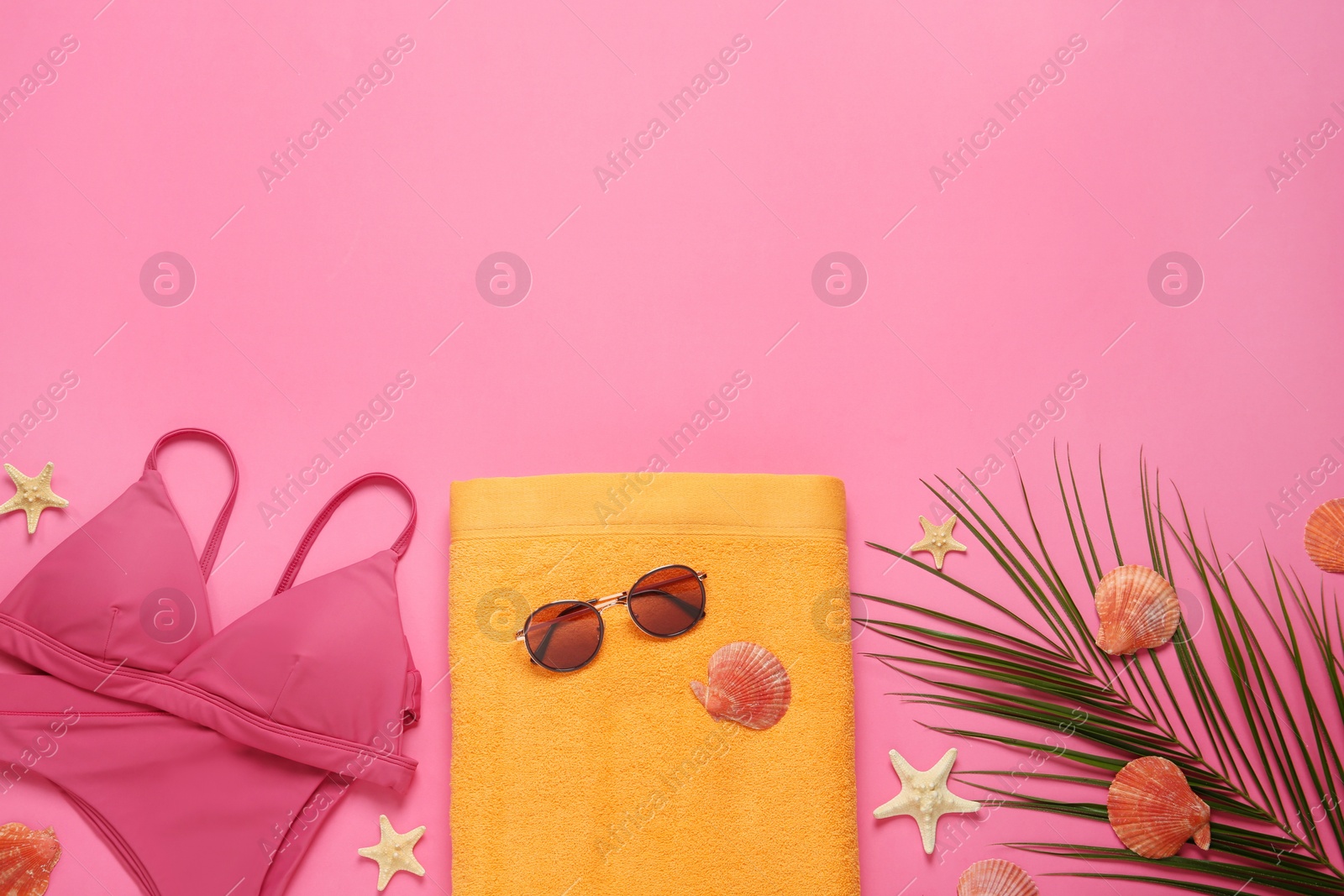 Photo of Flat lay composition with different beach objects on pink background, space for text