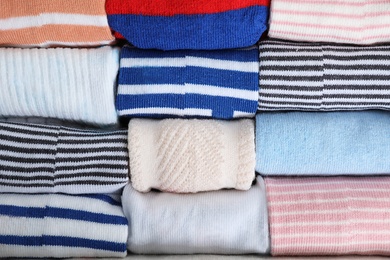 Photo of Many cute child socks as background, top view