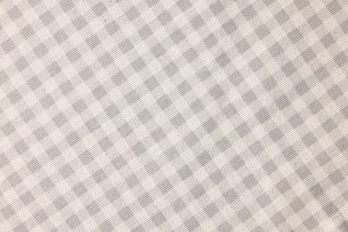 Beige checkered tablecloth as background, top view