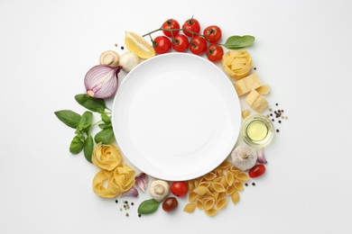 Plate surrounded by different types of pasta, products and peppercorns on white background, flat lay. Space for text