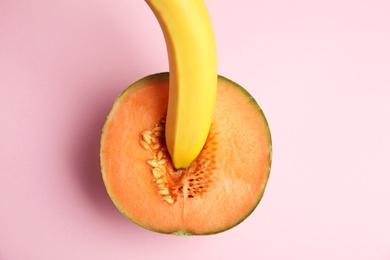 Flat lay composition with fresh banana and melon on pink background. Sex concept