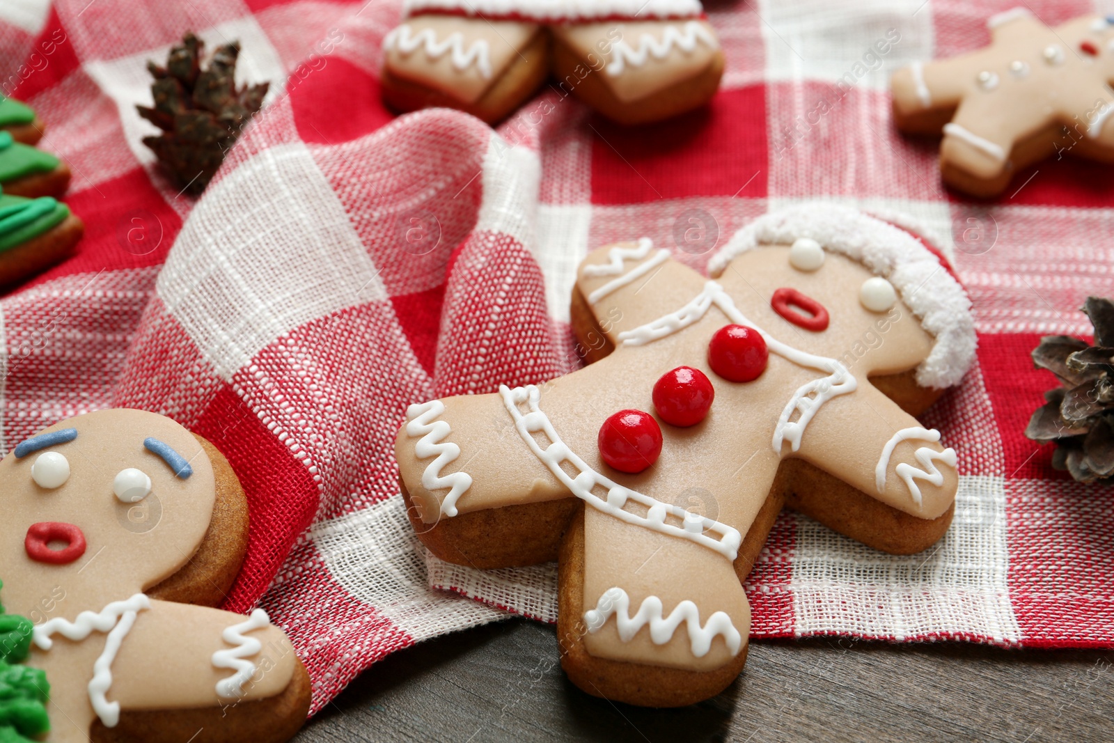 Photo of Delicious Christmas cookies and pine cones on wooden table, closeup