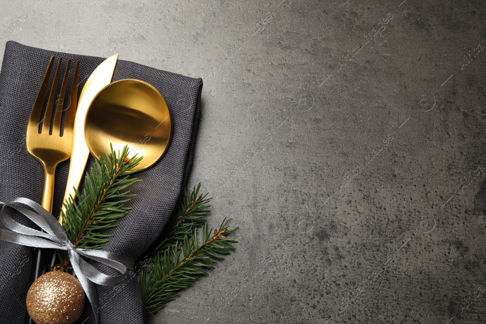 Photo of Cutlery set and Christmas decor on grey table, flat lay. Space for text