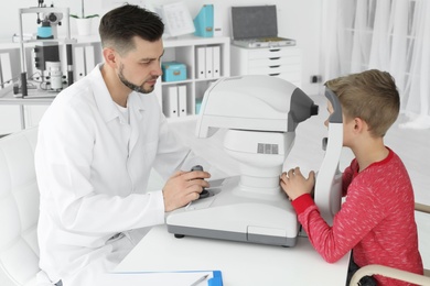 Ophthalmologist examining little boy in clinic