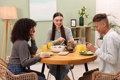 Happy friends having vegetarian meal in cafe