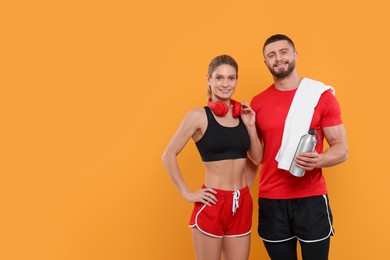 Athletic people with headphones, thermo bottle and towel on yellow background, space for text