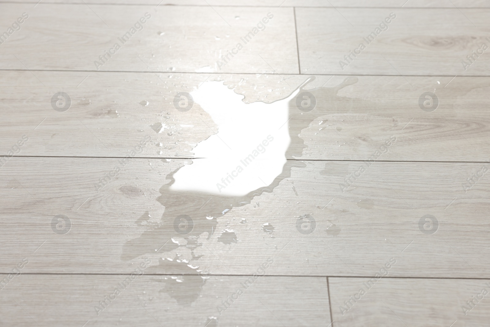 Photo of Puddle of spilled water on white laminated floor