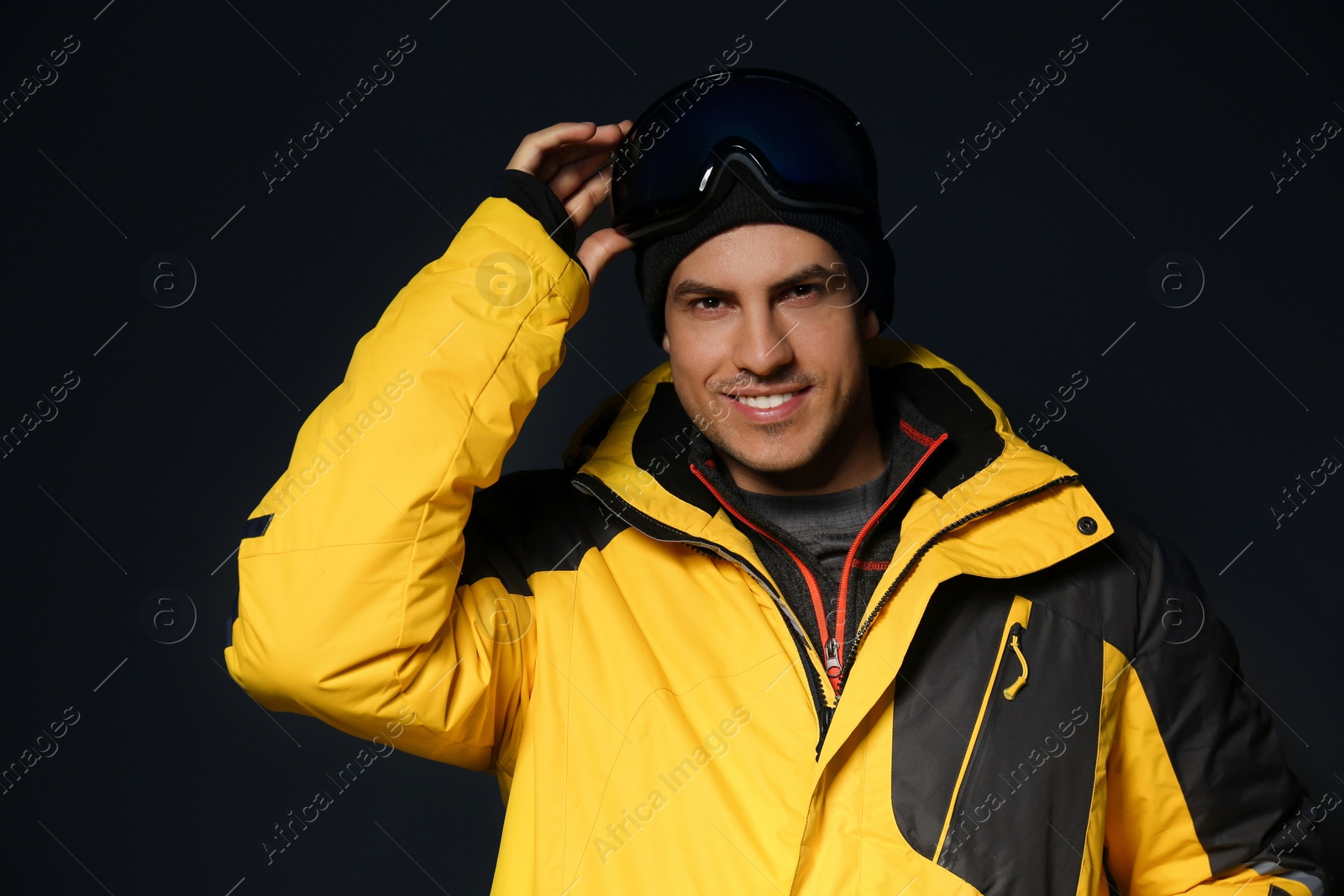 Photo of Man wearing stylish winter sport clothes on black background