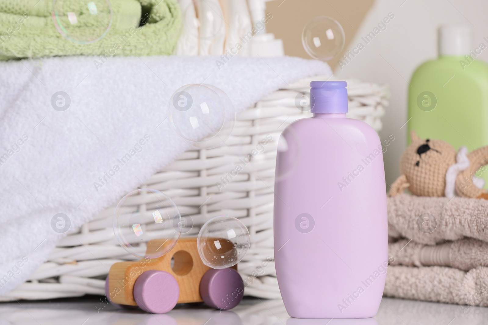 Photo of Baby cosmetic products, toys, diapers and towels on white table. Space for text