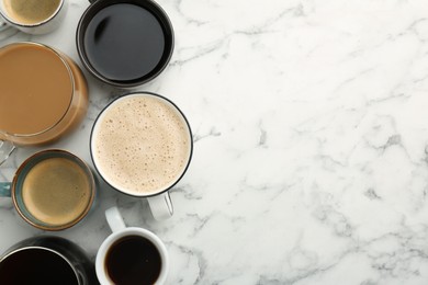 Photo of Different coffee drinks in cups on white marble table, flat lay. Space for text