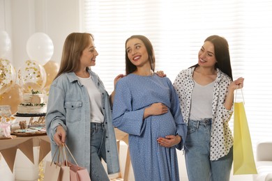 Photo of Happy pregnant woman spending time with friends at baby shower party