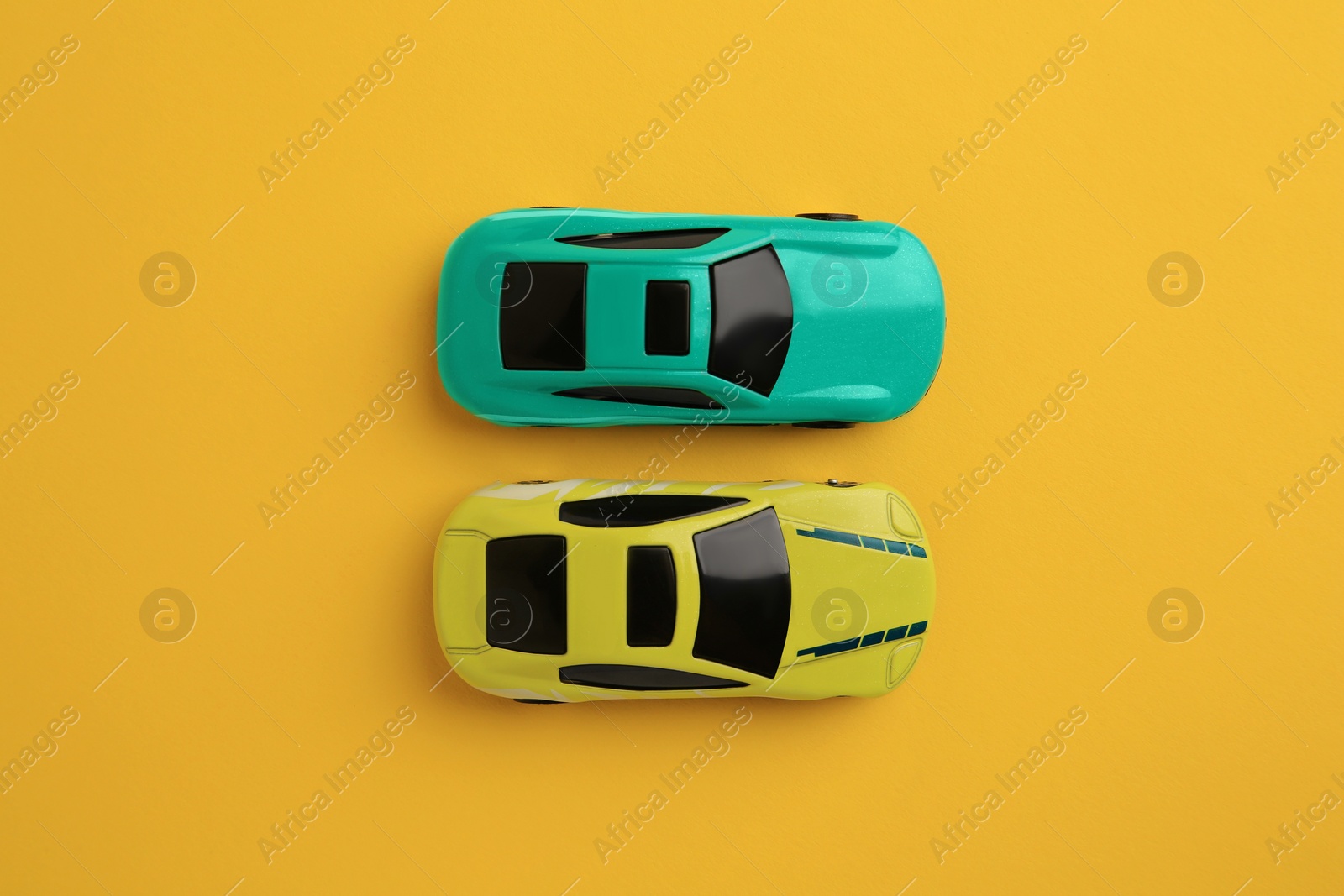 Photo of Bright cars on yellow background, flat lay. Children`s toys