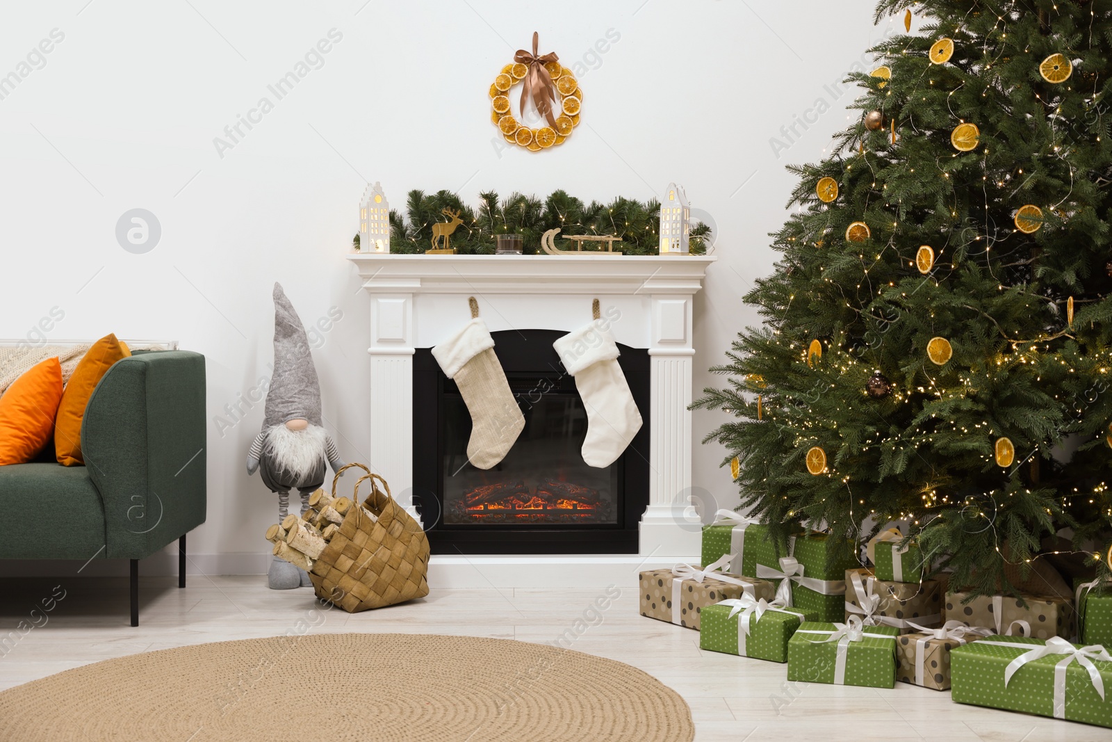 Photo of Cozy living room with fireplace and gifts under Christmas tree. Interior design