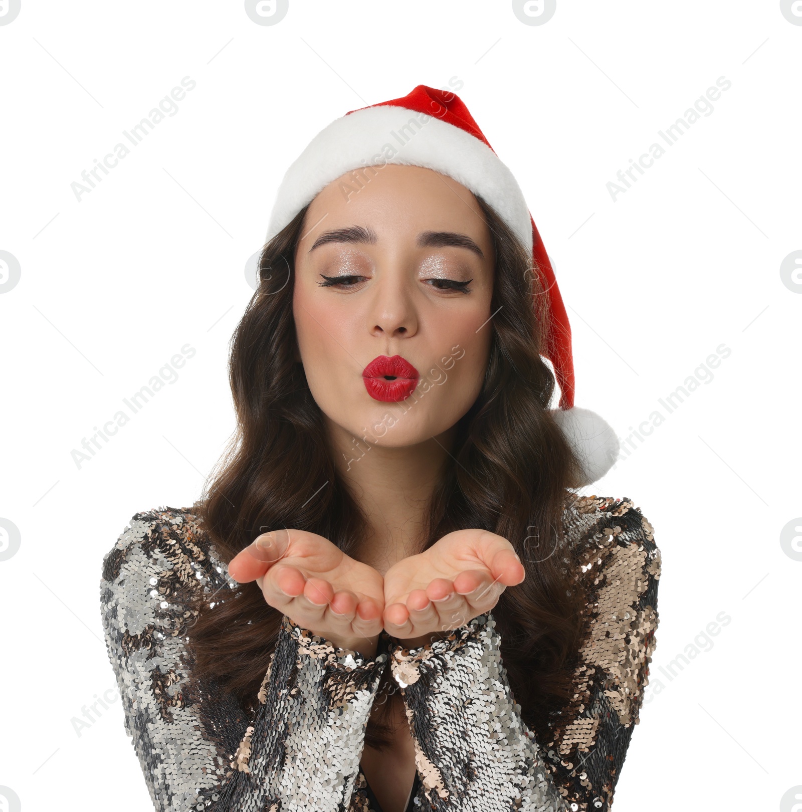 Photo of Christmas celebration. Beautiful young woman in Santa hat blowing kiss on white background