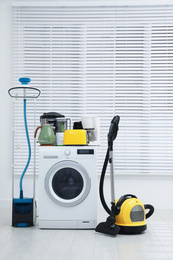 Photo of Different household appliances near window in room