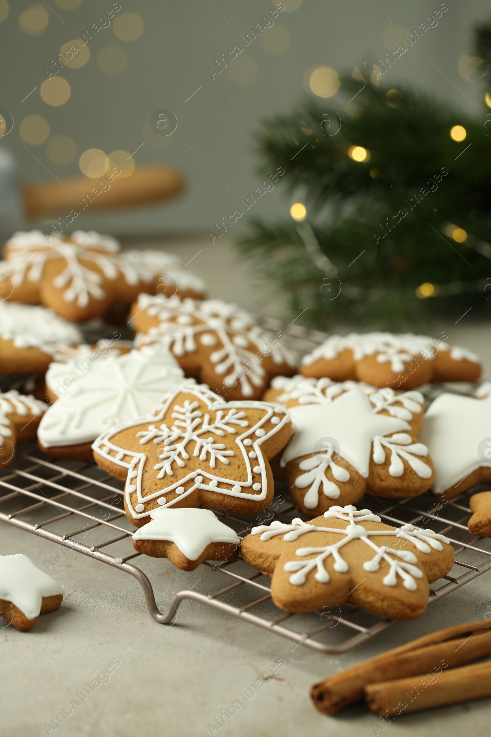 Photo of Tasty Christmas cookies with icing and cinnamon sticks on table