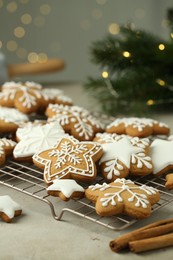 Photo of Tasty Christmas cookies with icing and cinnamon sticks on table