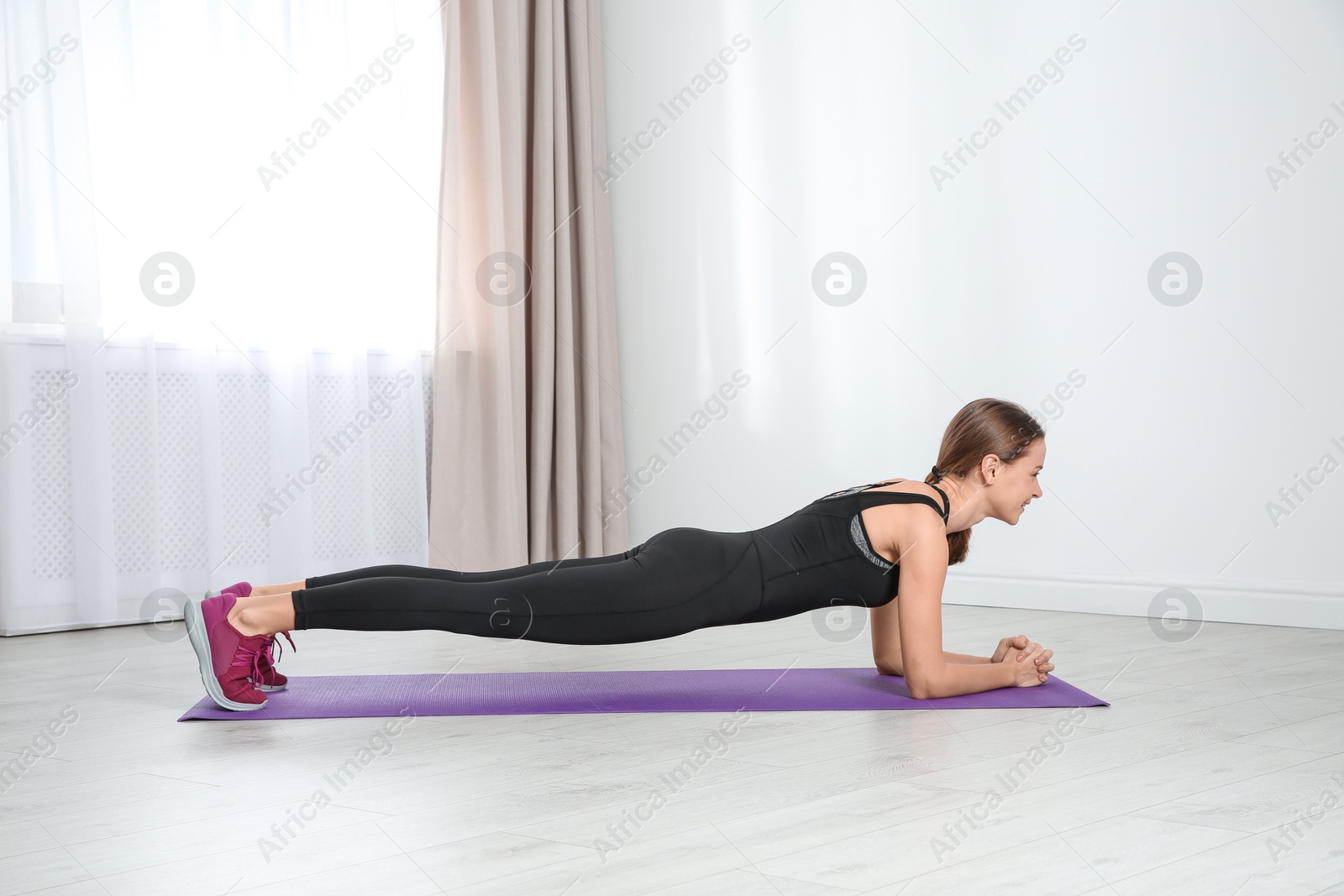 Photo of Young woman doing fitness exercises at home