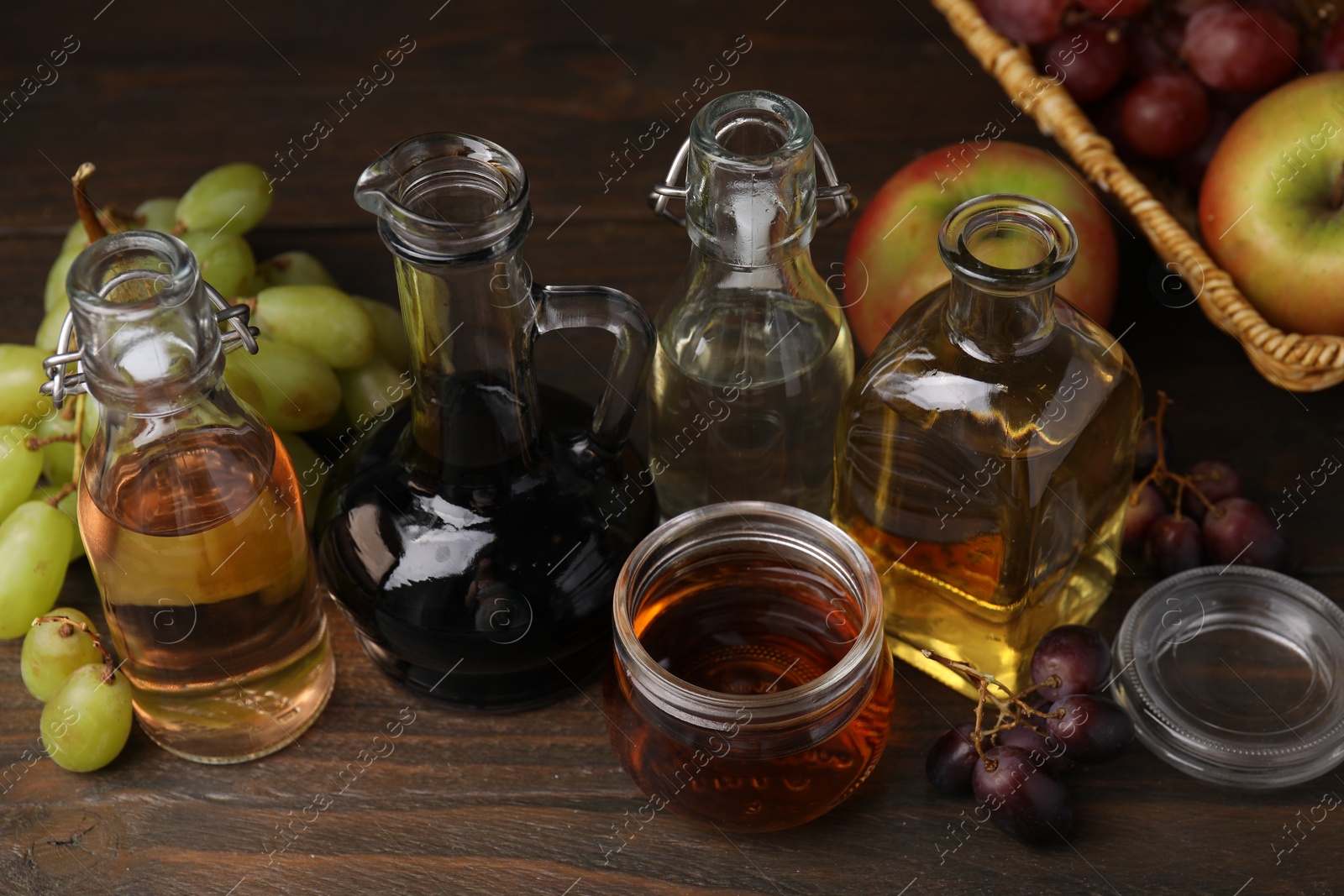 Photo of Different types of vinegar and fresh fruits on wooden table