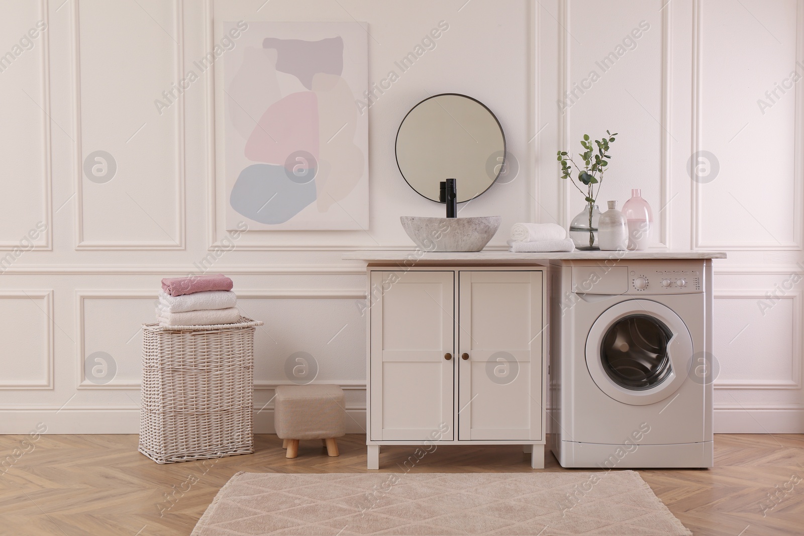 Photo of Laundry room interior with modern washing machine and stylish vessel sink on countertop