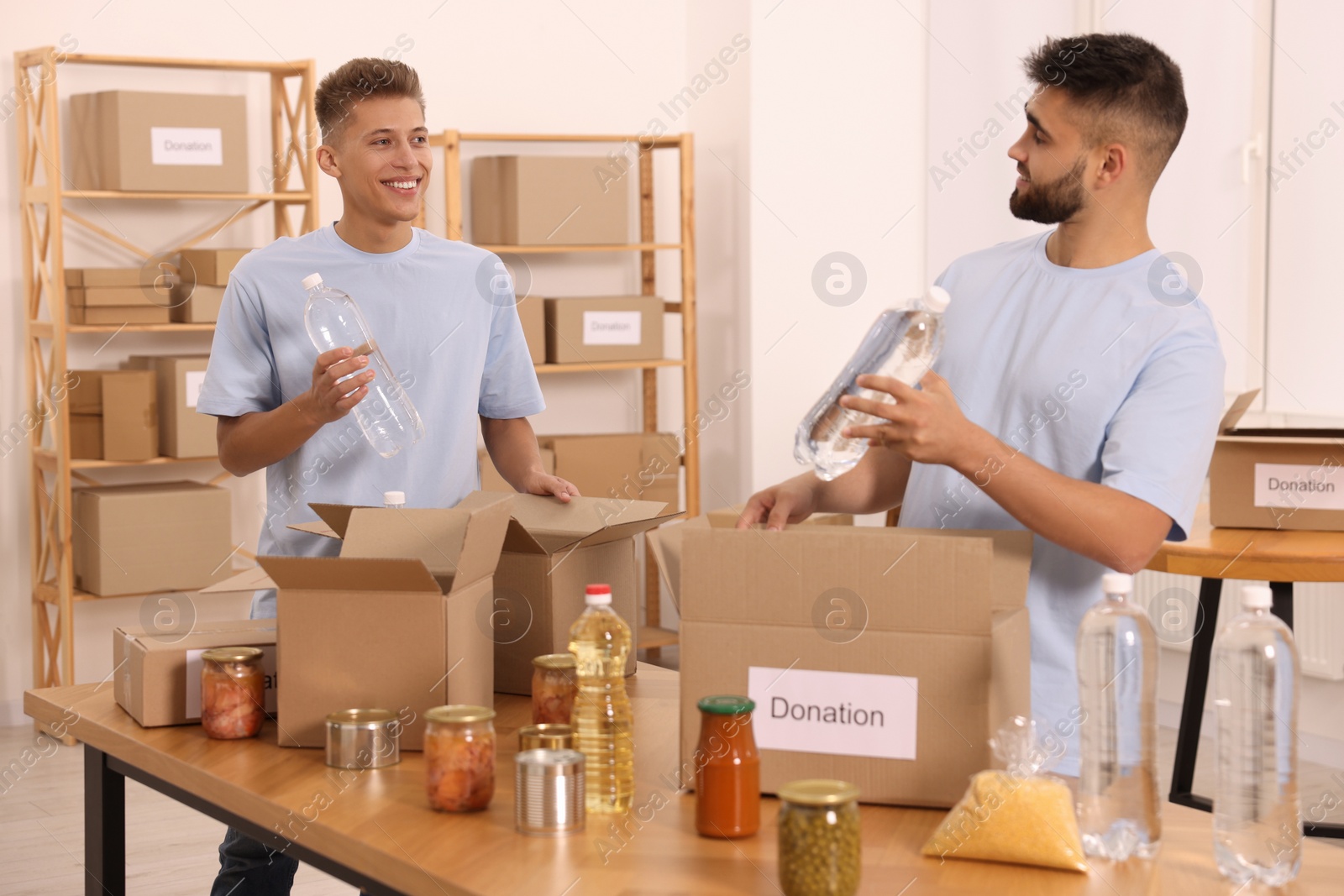 Photo of Volunteers packing food products at table in warehouse