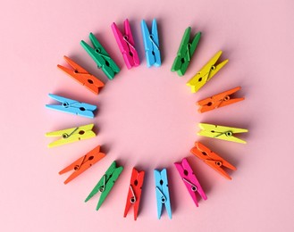 Frame of many different colorful clothes pins on pink background, flat lay. Diversity concept