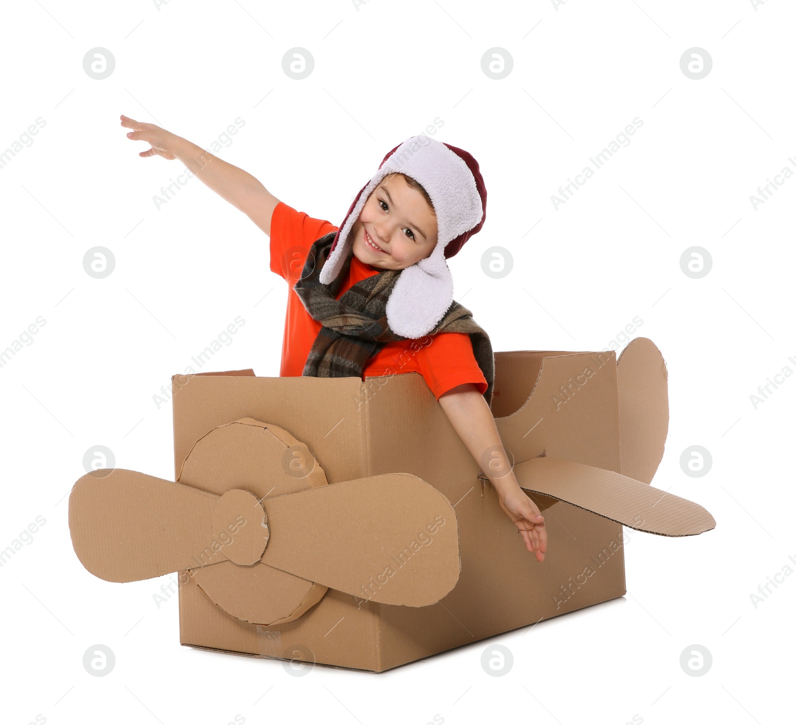 Photo of Cute little boy playing with cardboard airplane on white background