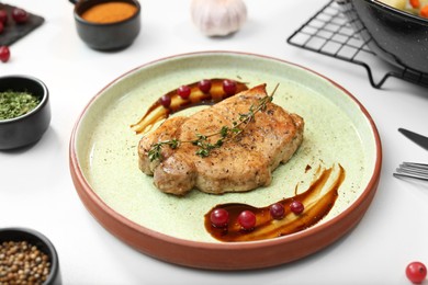 Photo of Beautiful composition with plate of delicious meat on white table in studio. Food stylist