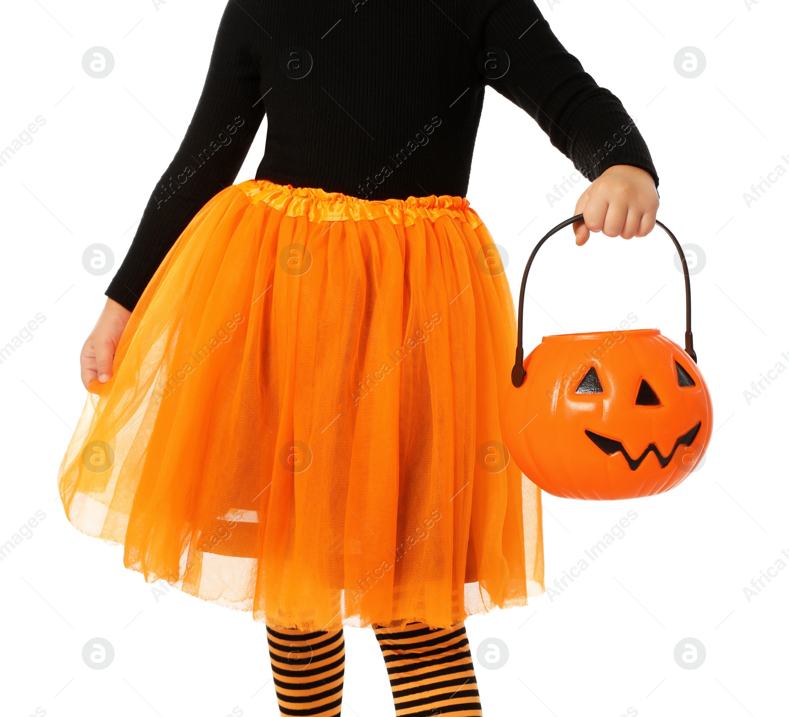 Photo of Cute little girl with pumpkin candy bucket wearing Halloween costume on white background, closeup