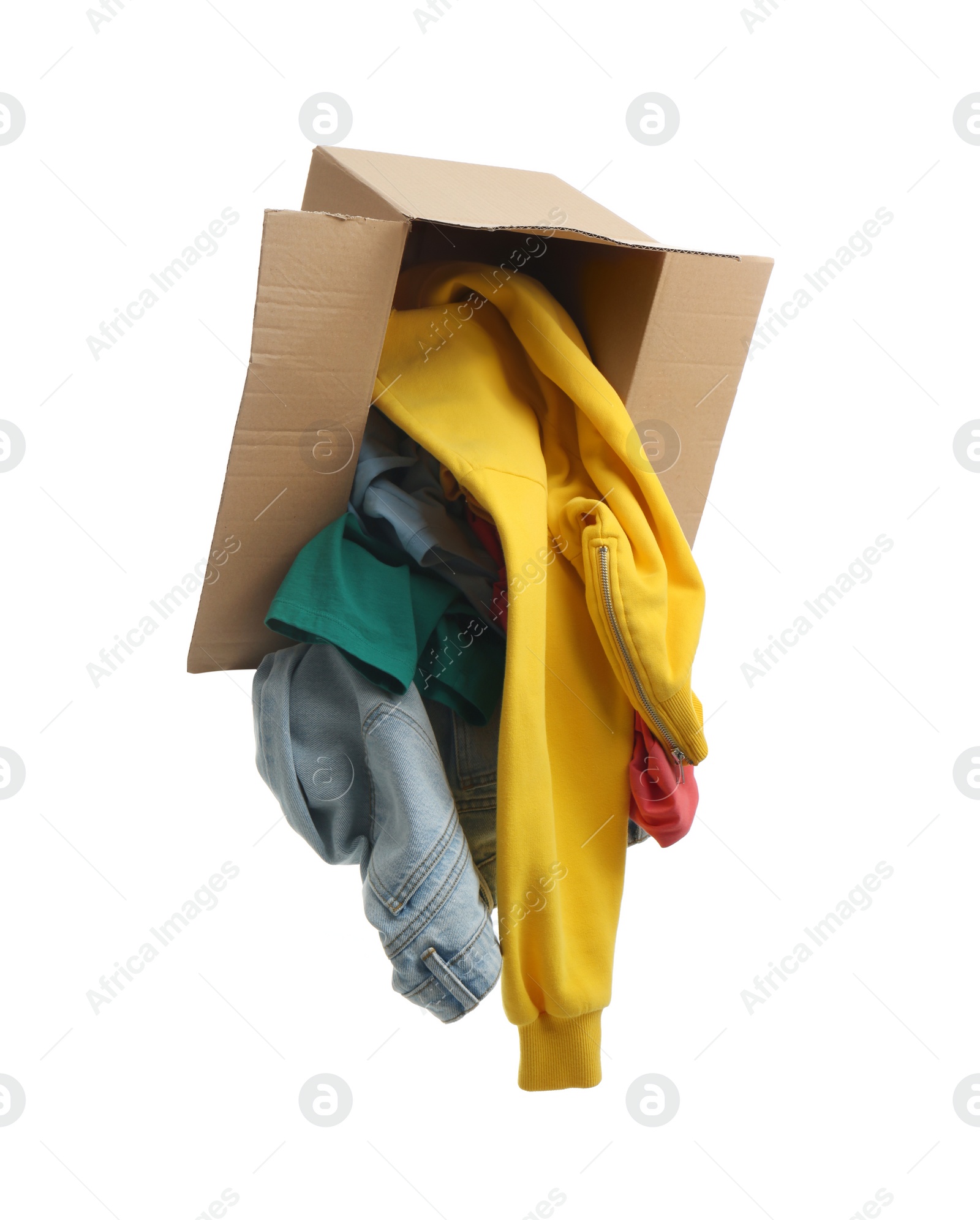 Photo of Overturned cardboard box with clothes isolated on white