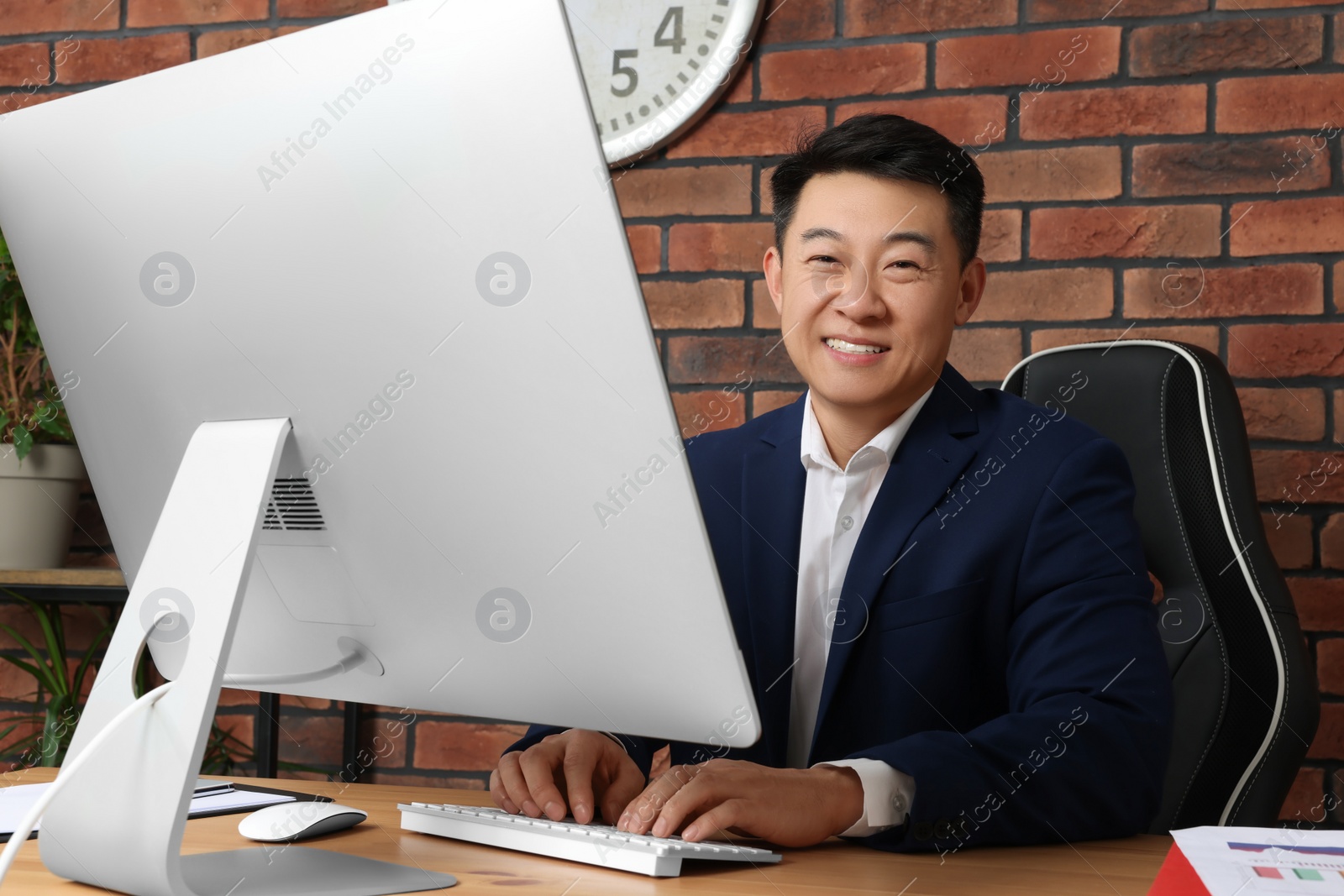 Photo of Happy boss working in his modern office